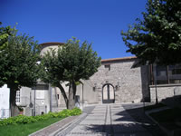 L'ingresso dell'Episcopio, su cui spiccano il bel portale in pietra e la torre cilindrica, parzialmente coperta dagli alberelli